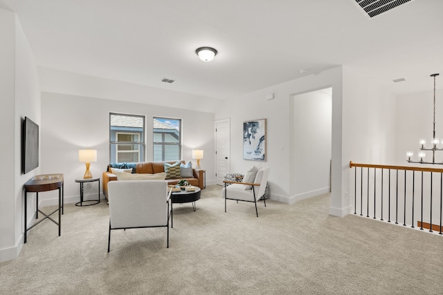 living room featuring light carpet and a chandelier