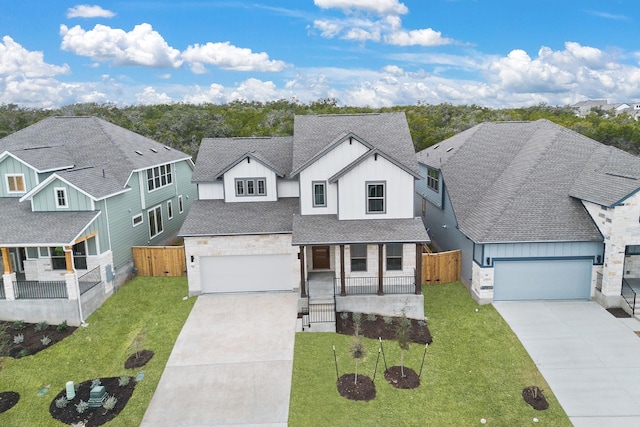 view of front of house featuring a garage, covered porch, and a front lawn