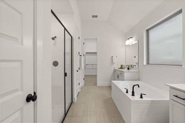 bathroom with vanity, vaulted ceiling, and separate shower and tub