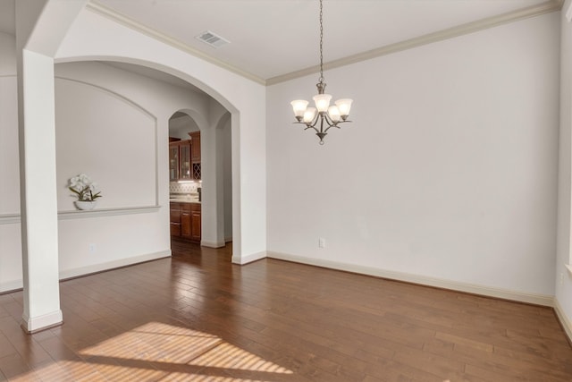 unfurnished room with a notable chandelier, dark hardwood / wood-style floors, and crown molding