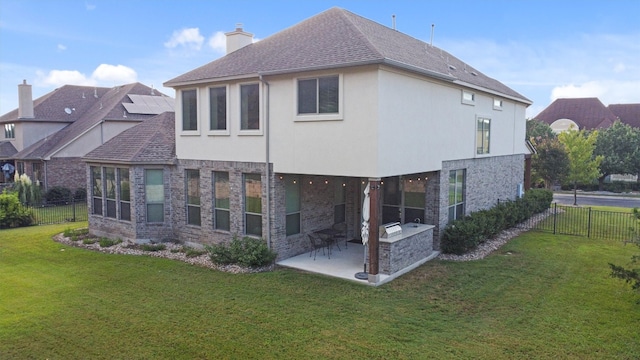 back of house with a lawn and a patio area