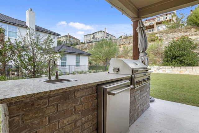 view of patio with exterior kitchen, area for grilling, and sink