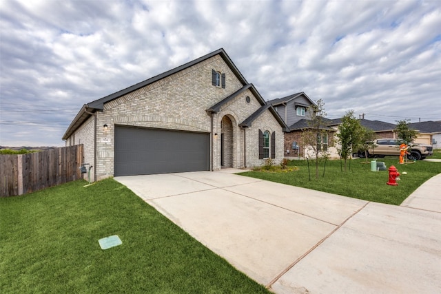 french country home featuring a garage and a front lawn