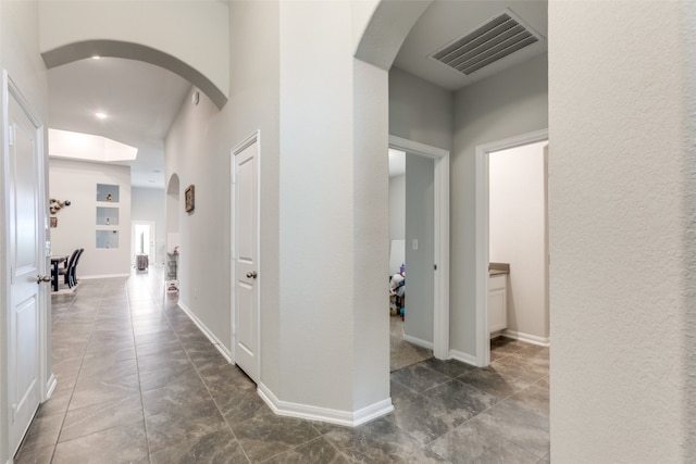 hallway featuring dark tile patterned floors