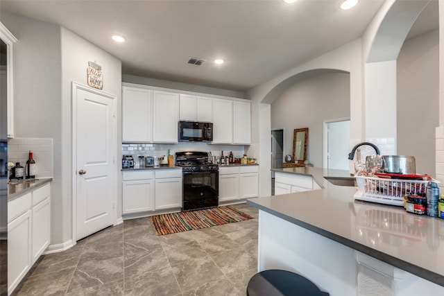 kitchen featuring white cabinetry, sink, black appliances, kitchen peninsula, and tasteful backsplash