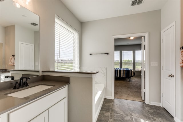 bathroom with vanity, tile patterned floors, and a bathtub