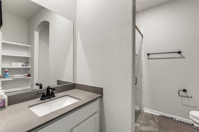 bathroom with tile patterned flooring, vanity, toilet, and walk in shower