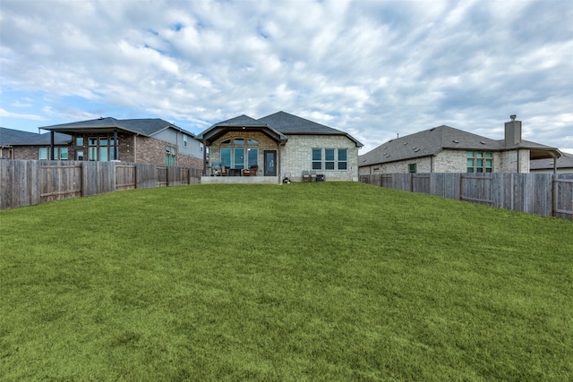 rear view of property with a yard