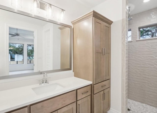 bathroom featuring a tile shower and vanity