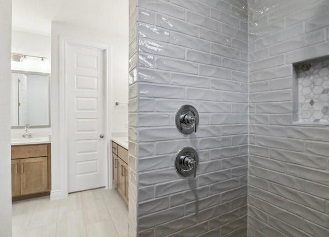 bathroom with tile patterned flooring, vanity, and walk in shower