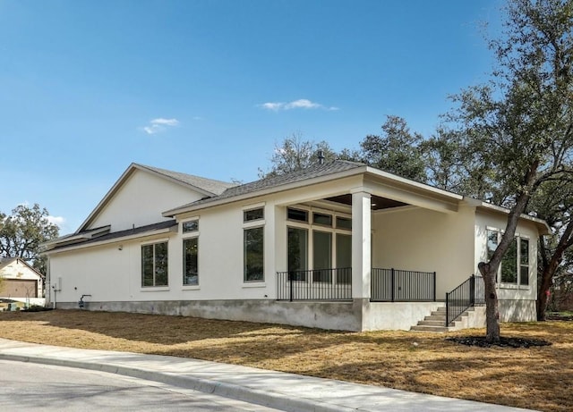 view of side of property featuring covered porch