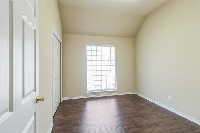 empty room featuring lofted ceiling and dark wood-type flooring