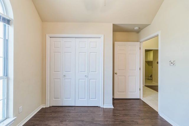 unfurnished bedroom with a closet and dark hardwood / wood-style flooring