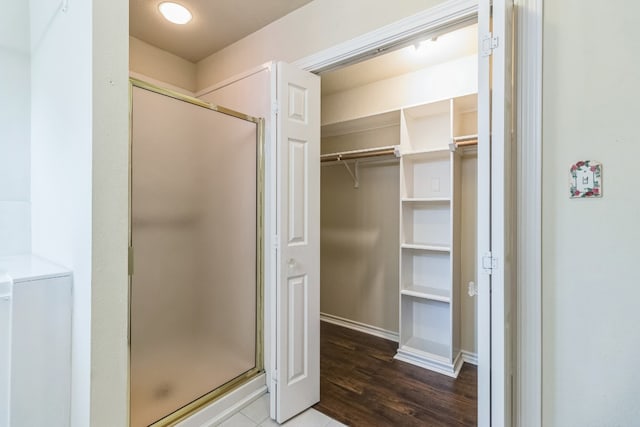 bathroom with walk in shower and hardwood / wood-style floors