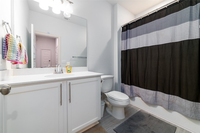 full bathroom featuring shower / bathtub combination with curtain, wood-type flooring, vanity, and toilet