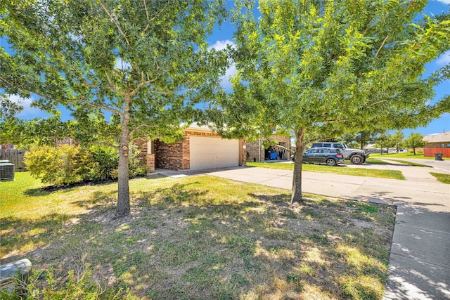 obstructed view of property with cooling unit, a garage, and a front yard