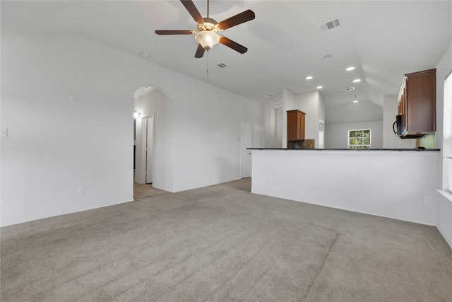 unfurnished living room featuring light carpet, lofted ceiling, and ceiling fan