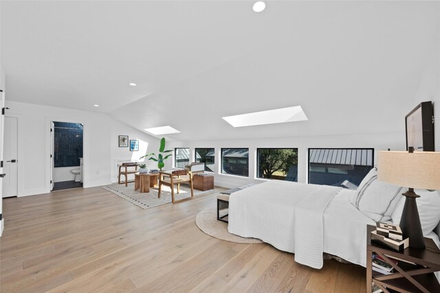 living room featuring hardwood / wood-style flooring and vaulted ceiling with skylight