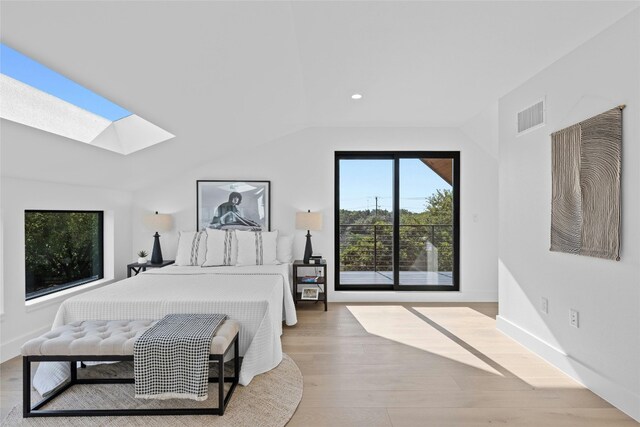 bedroom with light wood-type flooring and lofted ceiling with skylight