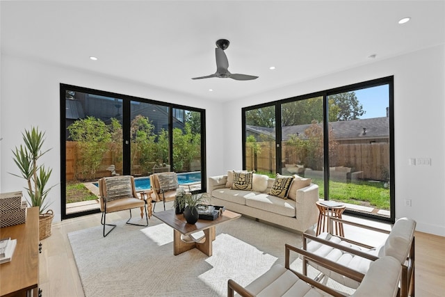 living room featuring a healthy amount of sunlight, ceiling fan, and light hardwood / wood-style flooring