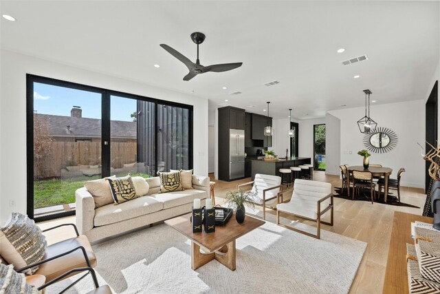 living room featuring light wood-type flooring and ceiling fan