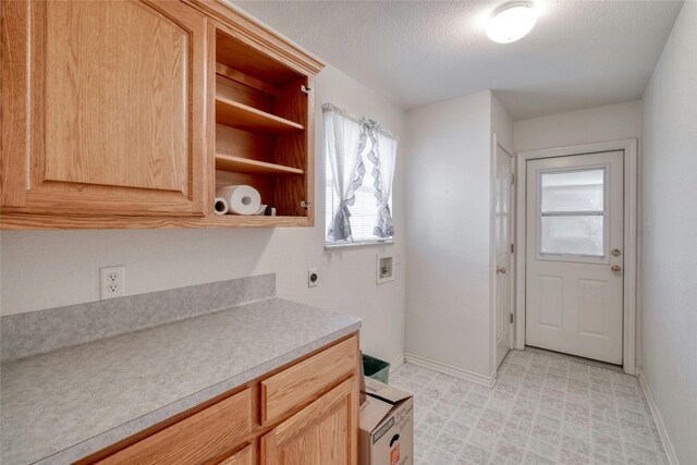 kitchen featuring light brown cabinetry and a textured ceiling