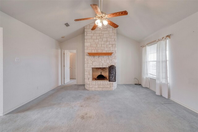 unfurnished living room with light carpet, a stone fireplace, lofted ceiling, and ceiling fan