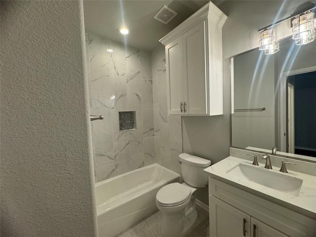 full bathroom featuring tiled shower / bath, vanity, and toilet