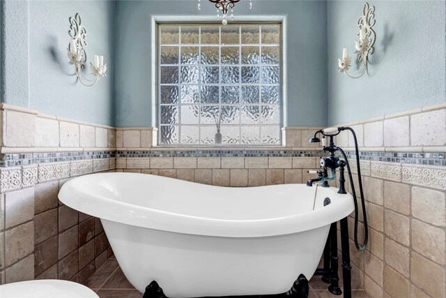 bathroom with tile walls, tile patterned floors, and a bathing tub