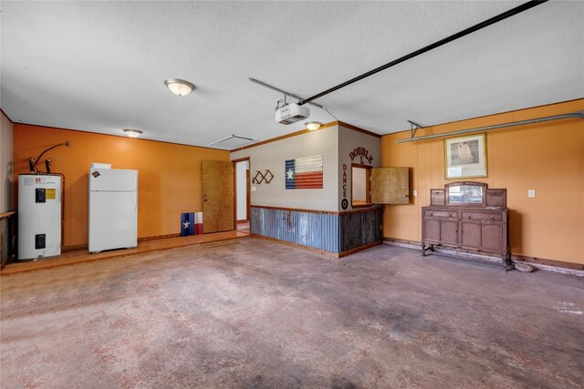 interior space with a garage door opener, electric water heater, and white fridge