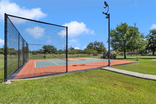 view of sport court with a yard