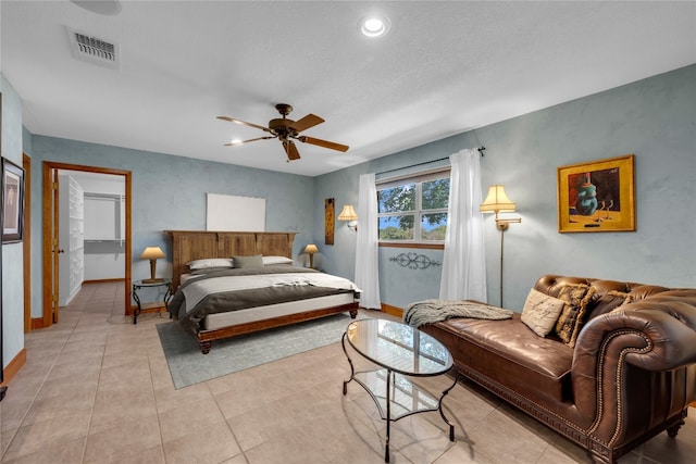 bedroom with ceiling fan, a textured ceiling, and light tile patterned floors