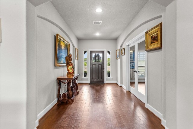 entrance foyer with a textured ceiling and dark wood-type flooring