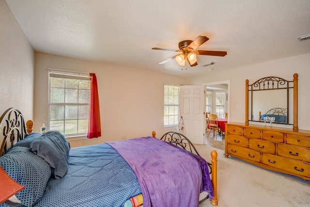 bedroom with ceiling fan and light carpet