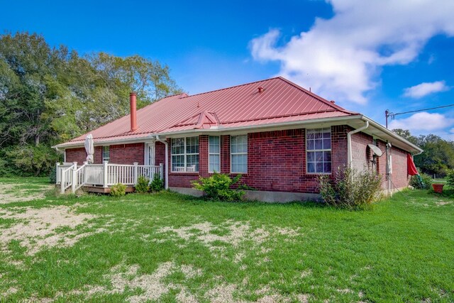 rear view of house with a yard and a deck