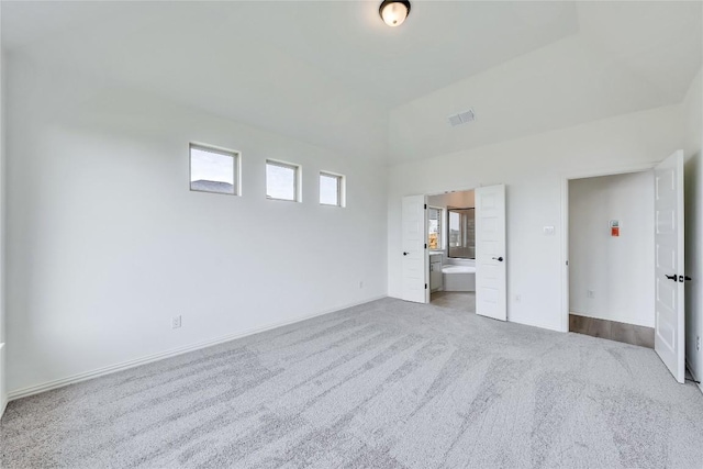 unfurnished room featuring plenty of natural light and light carpet