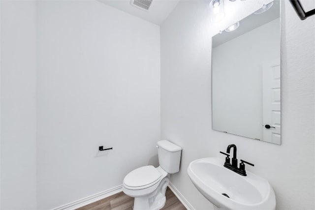 bathroom featuring hardwood / wood-style floors, toilet, and sink