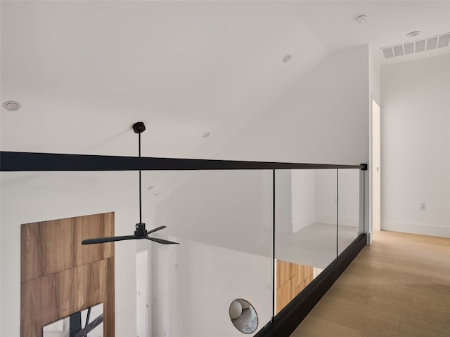 hall with vaulted ceiling, baseboards, visible vents, and light wood-style floors