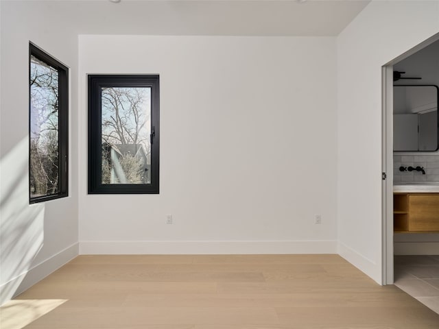 unfurnished room with light wood finished floors and baseboards