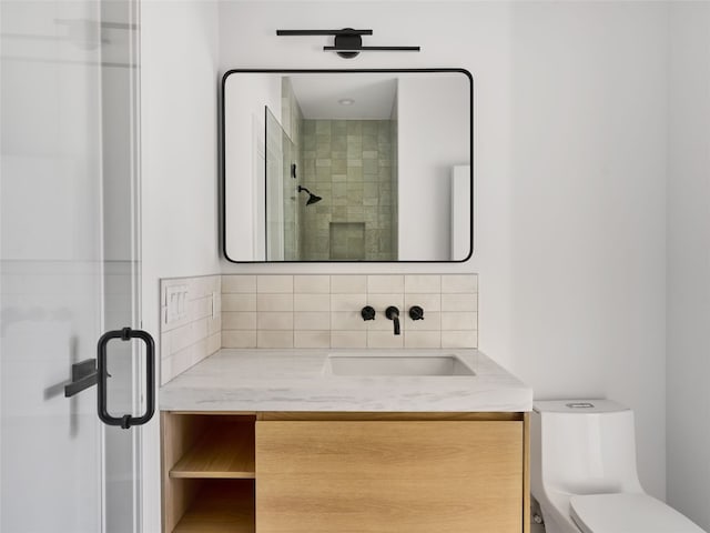 bathroom featuring toilet, a shower stall, decorative backsplash, and vanity