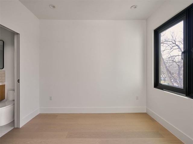 spare room featuring light wood-style flooring and baseboards