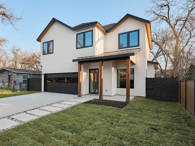 modern home with driveway, a standing seam roof, an attached garage, and fence