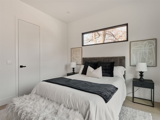 bedroom featuring wood finished floors and baseboards