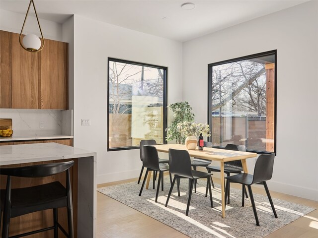 dining area featuring light wood-type flooring and baseboards