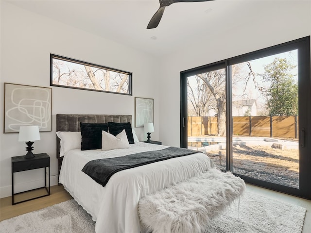 bedroom with light wood-style floors, access to outside, and a ceiling fan