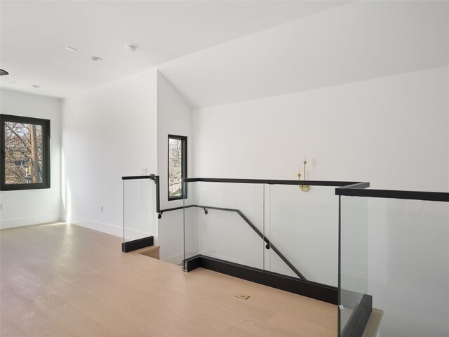 interior space featuring lofted ceiling, plenty of natural light, and wood finished floors