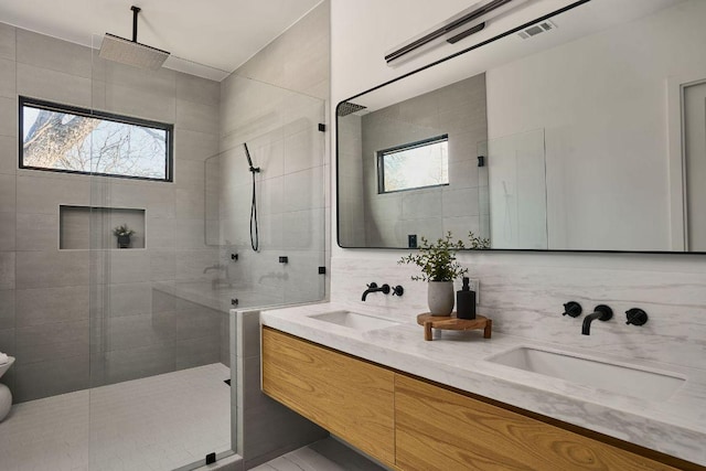 full bath with a wealth of natural light, decorative backsplash, and a sink