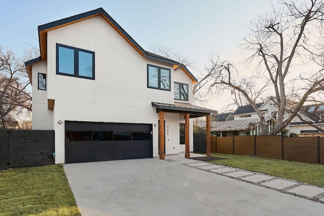 contemporary home with driveway, fence, and stucco siding