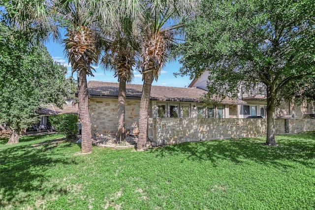 rear view of house featuring a yard