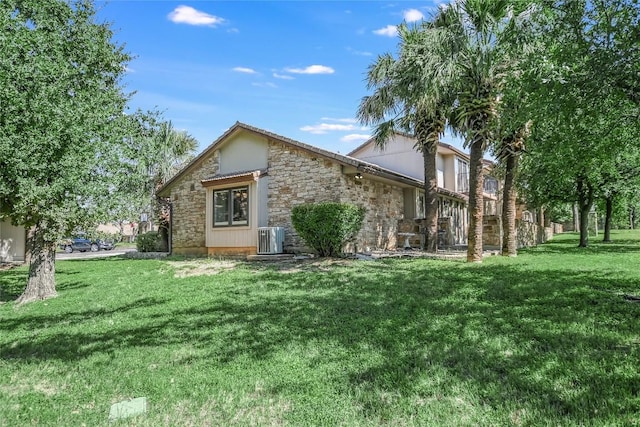 100 Bay Point Dr Unit 13, Horseshoe Bay, TX 78657 - back of house with stone siding, central air condition unit, and a lawn